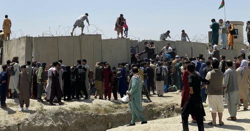 People attempt to climb into Kabul airport in the hope of fleeing Afghanistan. EPA
